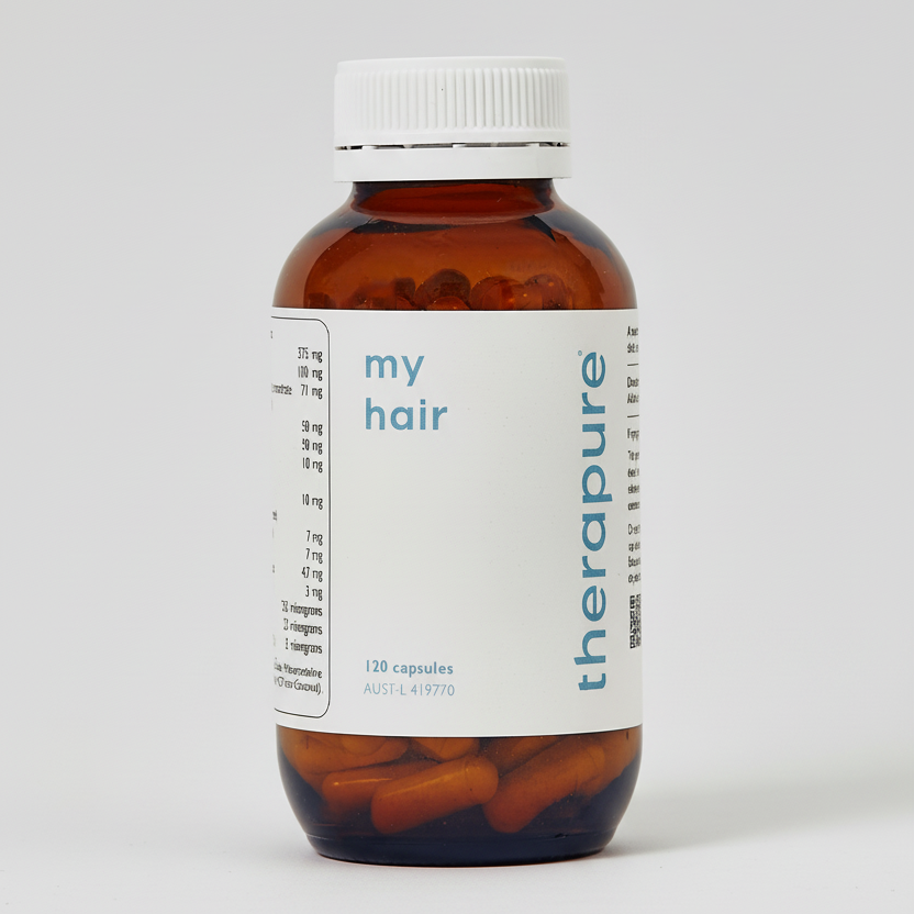 Bottle of 'therapure my hair' capsules on a white background
